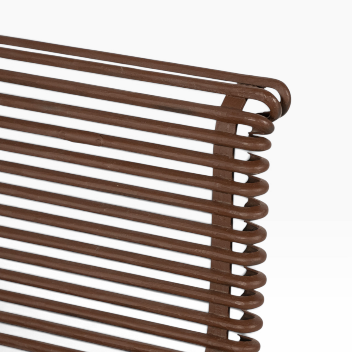 Close-up of The Well by BDAntiques rust-colored metal outdoor chair featuring a curved iron rod frame design.
