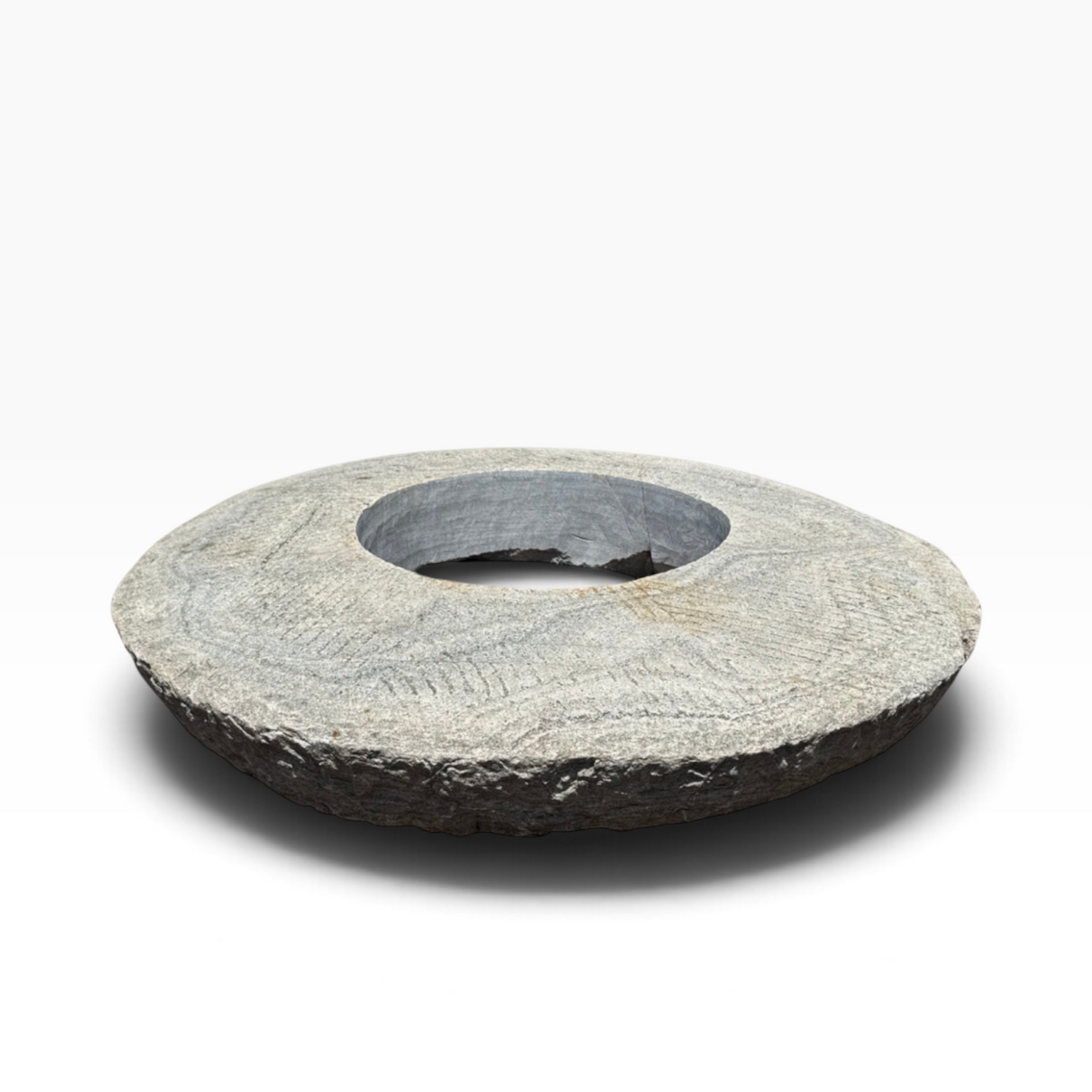 The Well by BDAntiques vintage millstone fire pit with a weathered grey stone texture and a central circular opening.