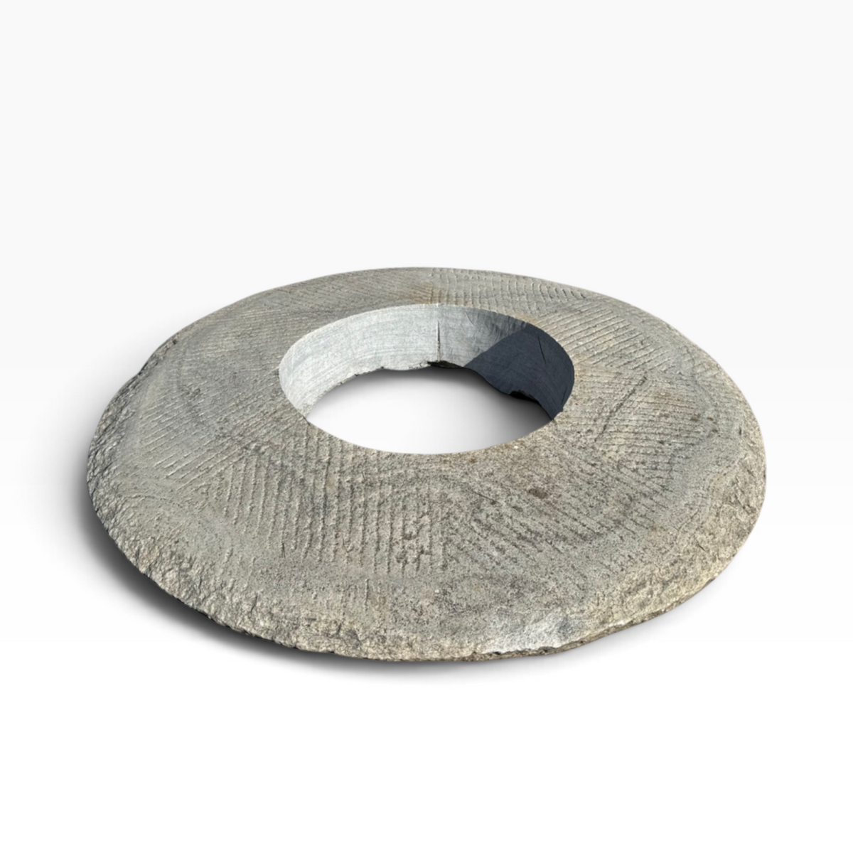 The Well by BDAntiques vintage millstone fire pit with a weathered grey stone texture and central hearth opening.