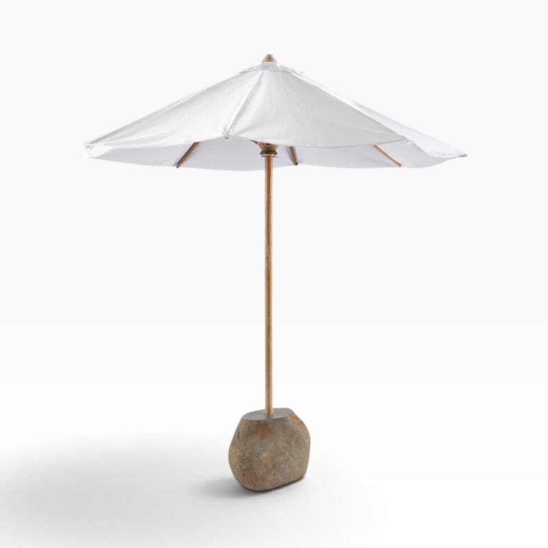 The Well by BDAntiques white patio umbrella with a wooden pole and natural stone base on a white background
