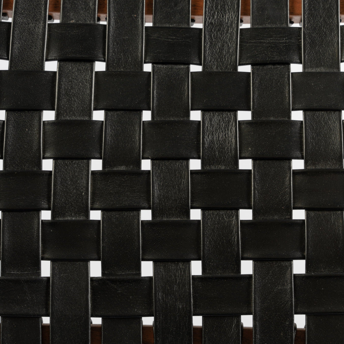 Close-up of black handwoven leather straps on a The Well by BDAntiques dining chair seat